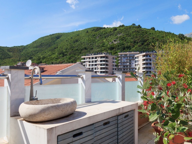 Three bedroom apartment with access to the roof and garage space in Budva